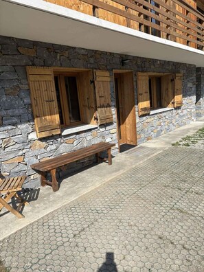 A stone building with wooden shutters, a bench, and a hexagonal tiled floor. - 220m from ski slopes, Ground floor, terrace, tv, ski locker, 45m², Valloire (Valloire)