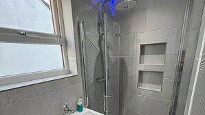 A modern bathroom with a shower, a window, and a sink. - Nice London flat with free private parking and 20 min train to central London (Bromley)