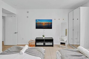 A modern bedroom with a bed, a TV mounted on the wall, a bedside table, and a wardrobe. - Midtown Miami Gem Wynwood W/ Huge Terrace Free Parking (Miami)
