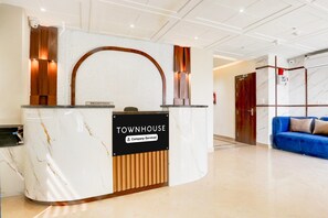 A reception desk with a marble top and a sign indicating it is a company-serviced townhouse.