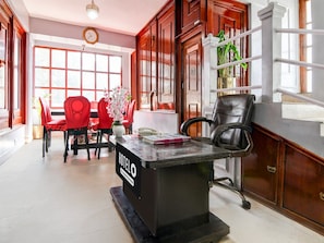 A hotel lobby with a reception desk, red chairs, a clock, and large windows. - Super Hotel O Ghoom Aps Homestay (Darjeeling)