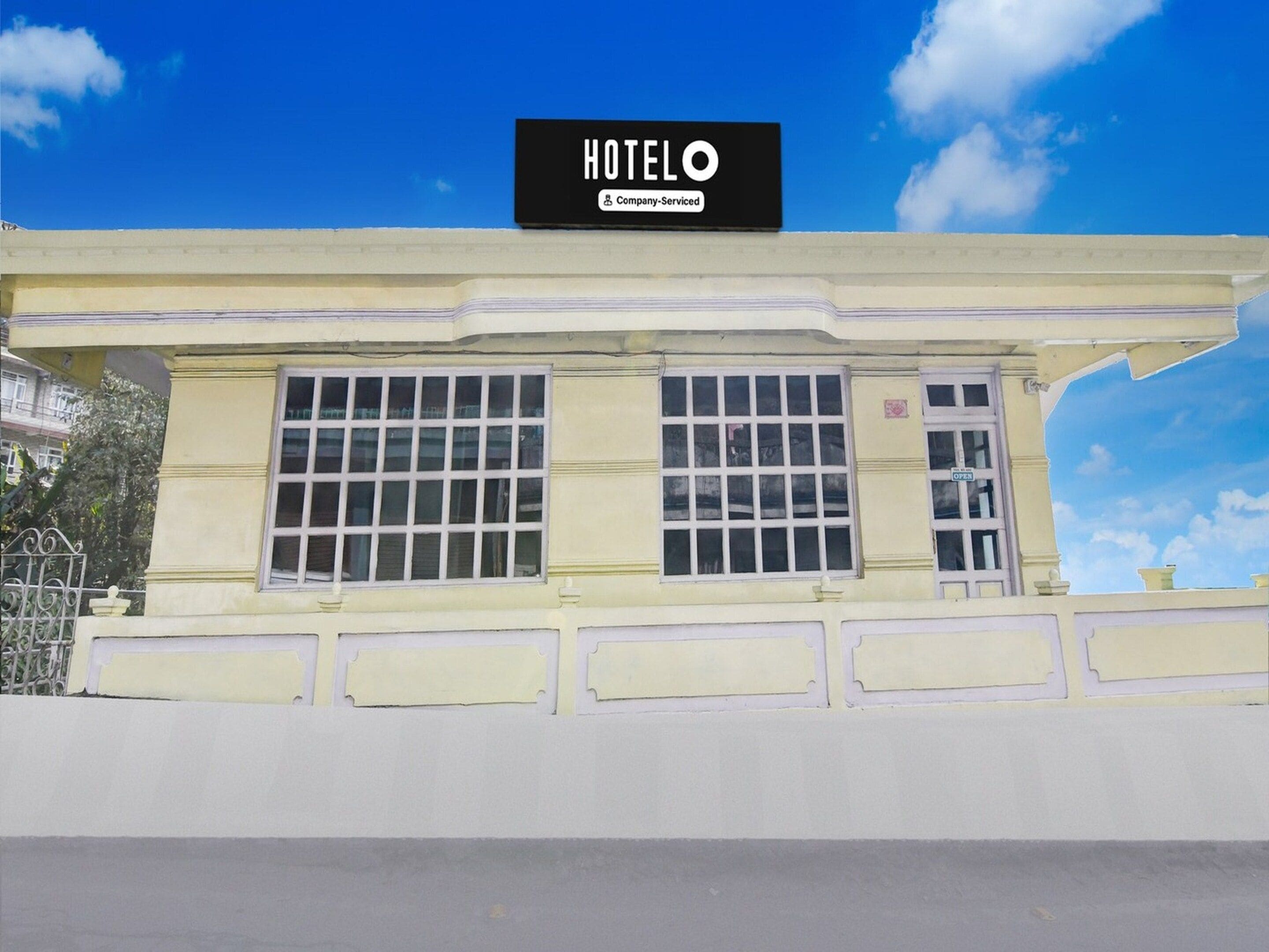A hotel building with a sign that reads 'HOTEL' and 'Company Serviced.'