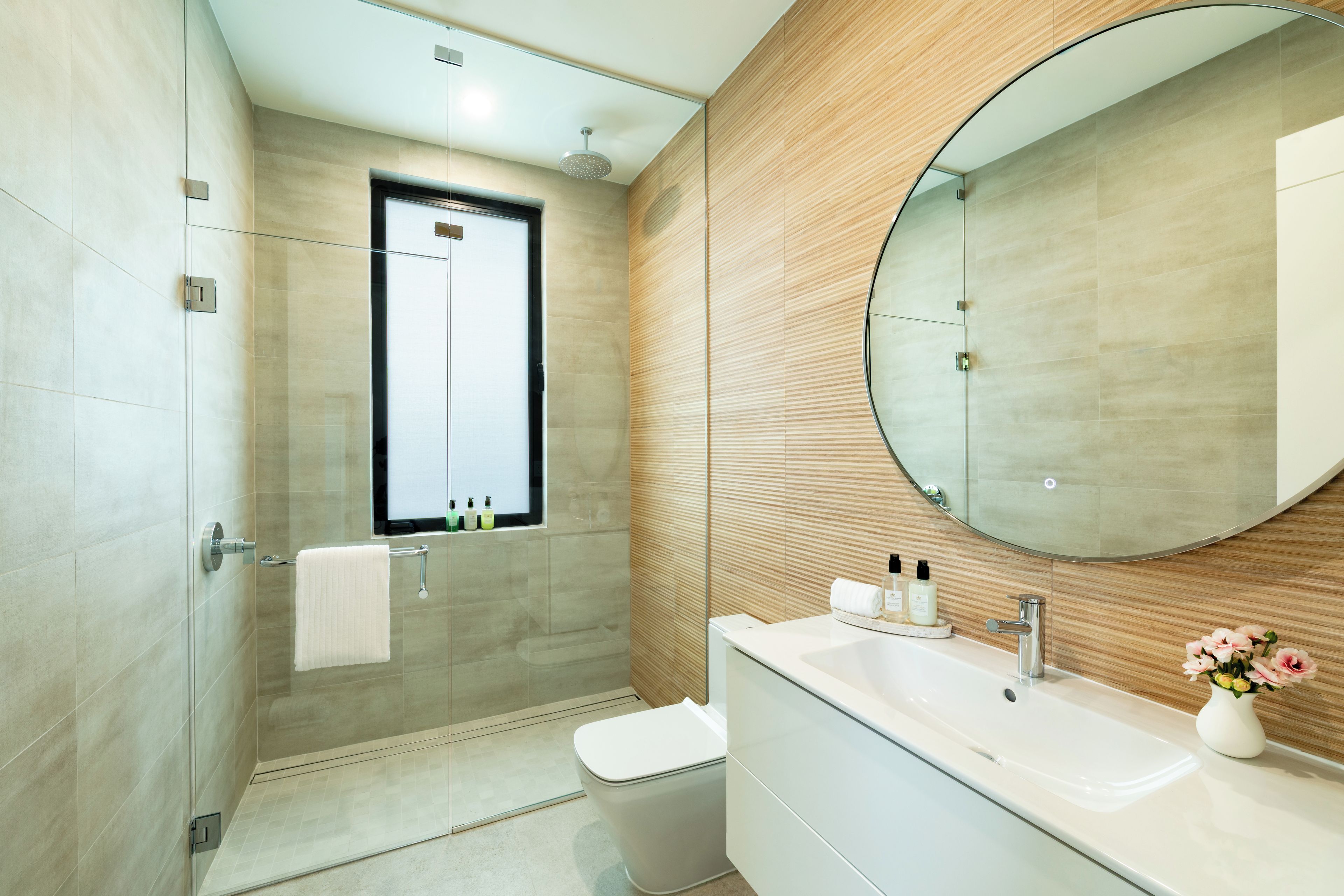 Une salle de bain moderne avec une douche à parois de verre, un meuble-lavabo et un grand miroir.