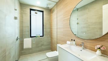 Une salle de bain moderne avec une douche à parois de verre, un meuble-lavabo et un grand miroir.