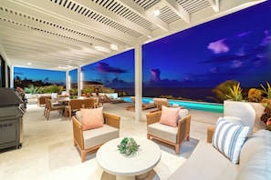 A covered outdoor area with a pool, lounge chairs, and a grill. - Villa Blue Ocean (Blue Mountain)