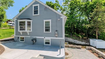 A two-story house with a front porch, a garage, and a small attached shed.