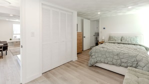 Een moderne slaapkamer met een groot bed, een kledingkast en een bureau.