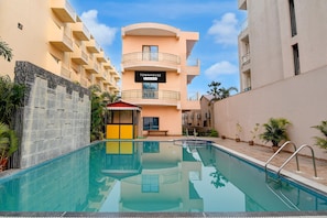 Ein Poolbereich, im Hintergrund ein Gebäude mit der Aufschrift 'TOWNHOUSE'.