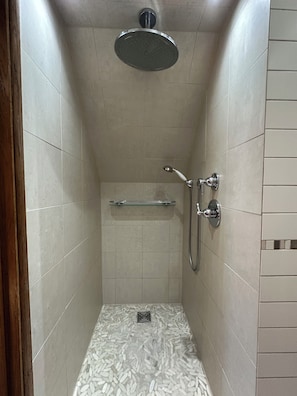A small, tiled shower stall with a handheld showerhead and a wall-mounted faucet. - My place of peace (Henfield)