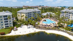 Ein Resort mit einem zentralen Pool, mehreren Gebäuden und einem Strandbereich.