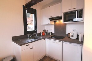 A compact kitchen with white cabinets, a microwave, a coffee maker, and a dishwasher. - 250m from ski lifts, 3rd floor, balcony, tv, 41m², Alpe d'Huez (L'Alpe d'Huez)