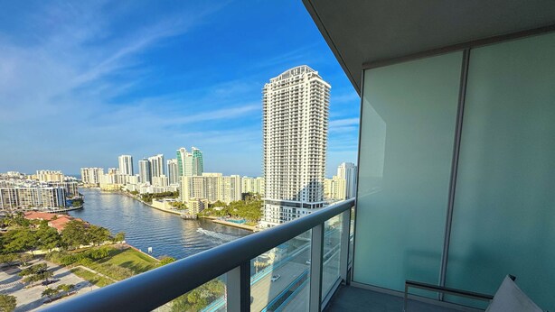 Uma varanda com vista para um rio e o horizonte da cidade.