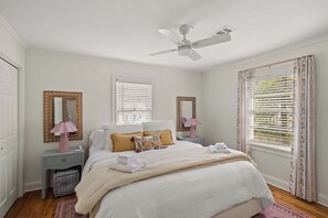 A bedroom with a bed, bedside tables, a ceiling fan, and a window with blinds. - The Sivley House (Oxford)