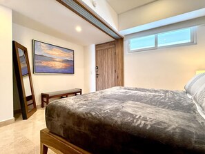 Ein Schlafzimmer mit einem Bett, einer Bank, einem Gemälde und einem Kleiderschrank.