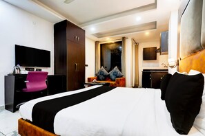 A hotel room with a bed, a desk, a television, and a wardrobe. - Super Townhouse Sector 52 (Gurugram)