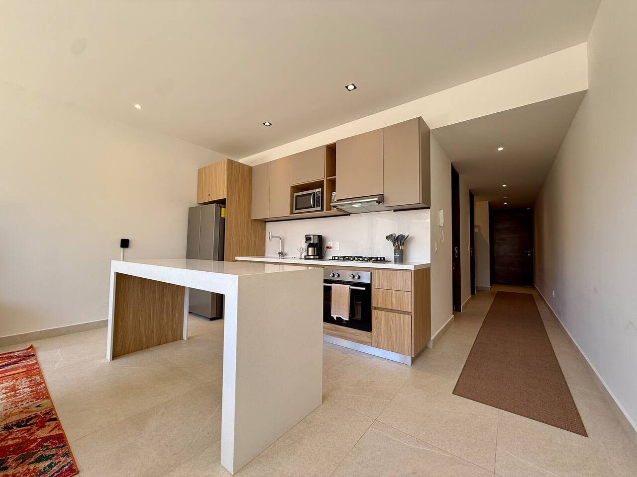 Een moderne keuken met een centraal eiland, inbouwapparatuur en een minimalistisch design.