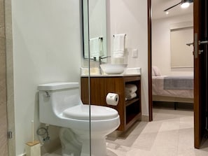 A bathroom with a toilet, a sink, and a mirror. - Brand-New 1BR Retreat with Spacious Patio in Bucerías (Bucerías)