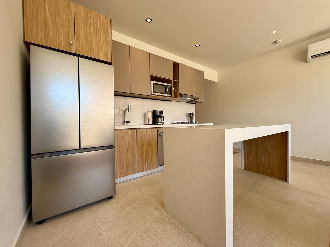 A modern kitchen with stainless steel appliances, wooden cabinets, and a central island.