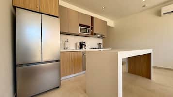 A modern kitchen with stainless steel appliances, wooden cabinets, and a central island.