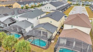 A residential area with multiple houses, a swimming pool, and a covered outdoor seating area. - 7BR Family Fun Estate - Arcade Room & Private Room (Kissimmee)
