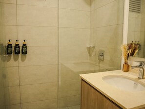 A bathroom with a large mirror, a sink, and three toiletries on the wall. - Santa Marina Sierra & Caribbean Retreat (Santa Marta)