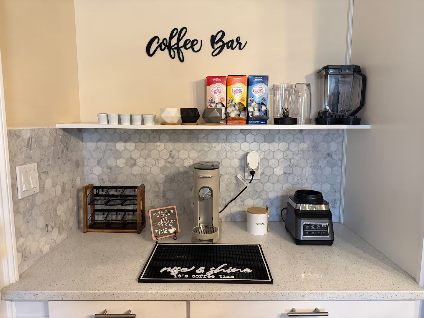 Eine Küche mit einer Kaffeebar, einschließlich Kaffeemaschine, Kaffeemühle und Aufbewahrung für Kaffeebohnen und Tassen.