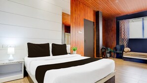 A modern bedroom with a large bed, wooden ceiling, and a view of the outdoors. - Collection O Jaigaon Near Bhutan Gate (Alipurduar)
