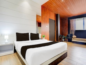 A modern bedroom with a large bed, wooden ceiling, and a view of the outdoors. - Collection O Jaigaon Near Bhutan Gate (Alipurduar)