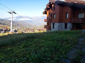 A multi-story building with balconies, set against a mountainous backdrop. - 10m from ski slopes, Ground floor, terrace, tv, ski locker, 27m², Valmorel (Valmorel)
