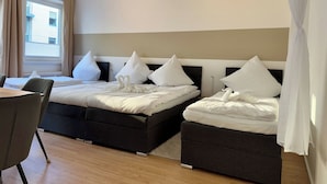 A hotel room with two beds, a dining table, and a chair. - Stylish Flat Central 6 Guests 65sqm (Hannover)