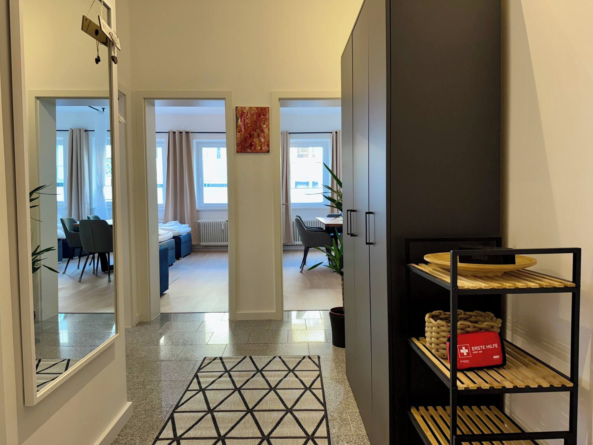 A modern apartment with a hallway leading to a living room, dining area, and a kitchen.