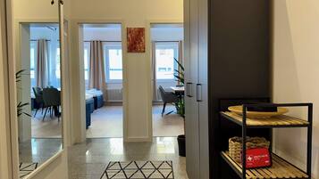 A modern apartment with a hallway leading to a living room, dining area, and a kitchen.