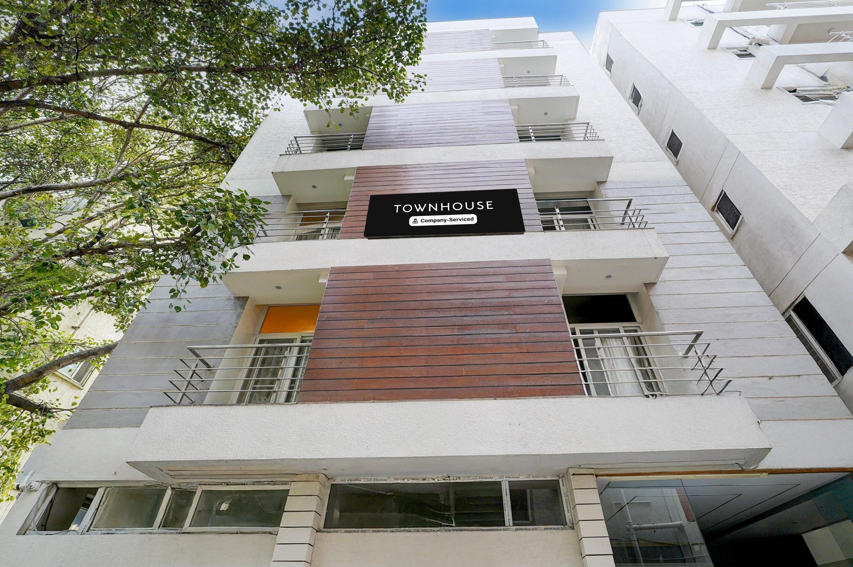 A multi-story building with a sign reading 'TOWNHOUSE' and 'Company Serviced.'