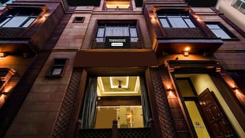 A townhouse with a sign reading 'TOWNHOUSE & Company-Service,' a central entrance with a ceiling fan, and a wooden door.