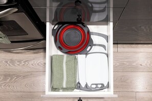 A kitchen drawer with a kettle, a cloth, and a container. - Cozy Little Portugal 2BR | Sleeps 6 (Toronto)