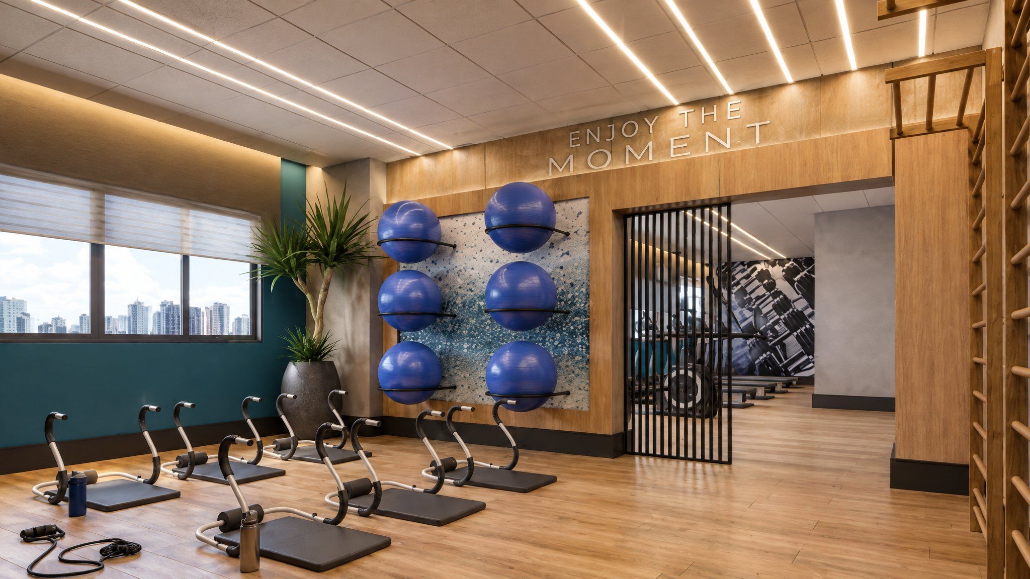 A gym with exercise equipment, a city view, and a motivational wall.