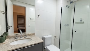 A modern bathroom with a granite countertop, a toilet, and a glass-enclosed shower. - Air Brooklin (São Paulo)