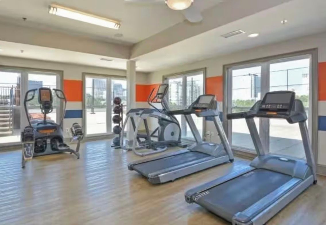 A gym with treadmills, ellipticals, and a stationary bike.