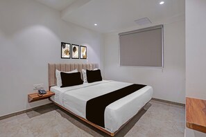 A modern bedroom with a bed, bedside table, and artwork on the wall.
