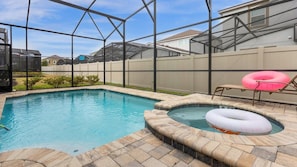 A backyard swimming pool with a hot tub and lounge chairs. - Magical Disney Retreat with Pool, Spa & Theater (Kissimmee)