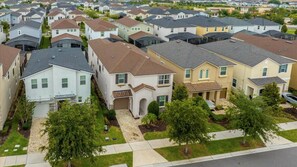 A residential area with multiple houses, some with attached garages, and well-maintained lawns. - Magical Disney Retreat with Pool, Spa & Theater (Kissimmee)
