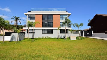 Un edificio moderno de dos pisos con techo plano, ventanas amplias y un letrero que dice "Sunset Villa".
