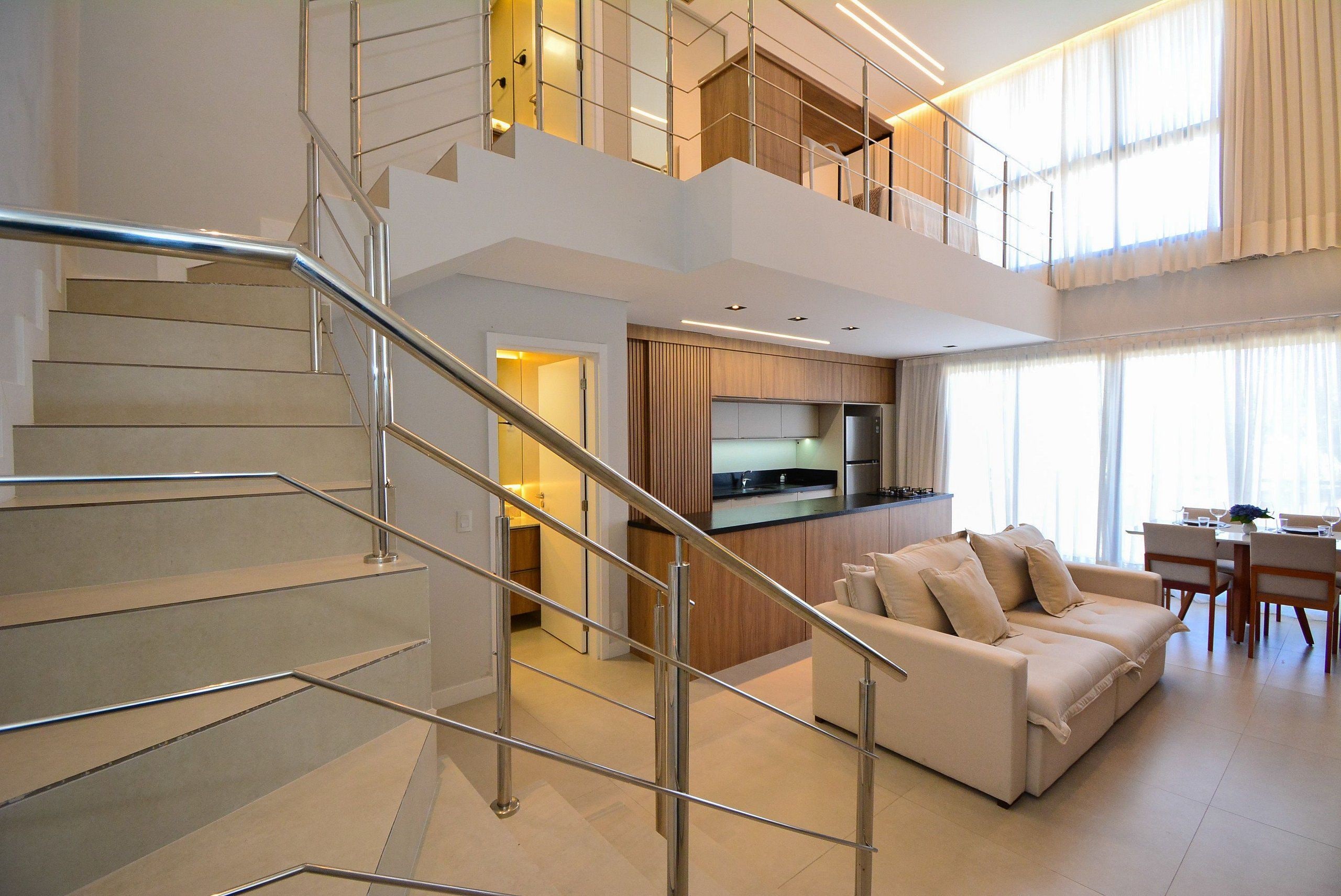 Un interior moderno con una escalera, una cocina, un comedor y una sala de estar.