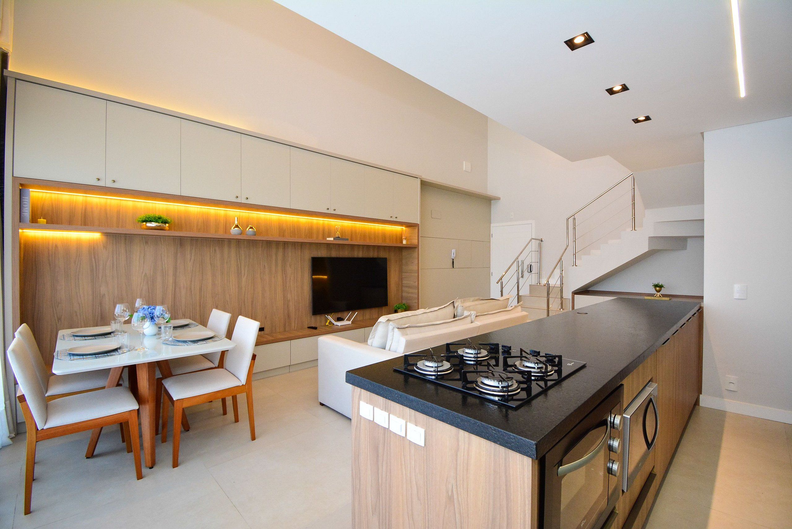 Una cocina moderna con comedor, electrodomésticos integrados y una escalera.