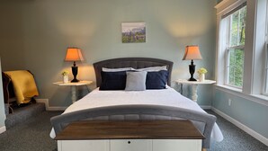 A bedroom with a bed, two bedside tables with lamps, a chair, a window, and a painting on the wall. - Breathtaking mountain view, private entrance, romantic getaway (Valdez)