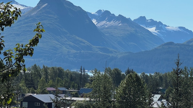 A mountain landscape with a clear sky, a few buildings in the foreground, and snow-capped peaks in the distance. - Breathtaking mountain view, private entrance, romantic getaway (Valdez)