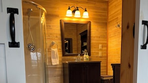 A bathroom with a shower, toilet, vanity, and a mirror. - Breathtaking mountain view, private entrance, romantic getaway (Valdez)