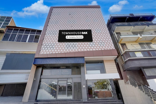 A modern building with a geometric facade and a sign indicating 'TOWNHOUSE OAK Company Serviced'.
