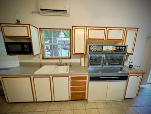 A compact kitchen with a built-in microwave, a sink, and a stove.