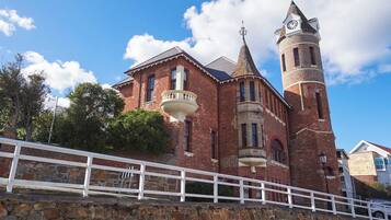 A historic building with a prominent clock tower and a balcony.